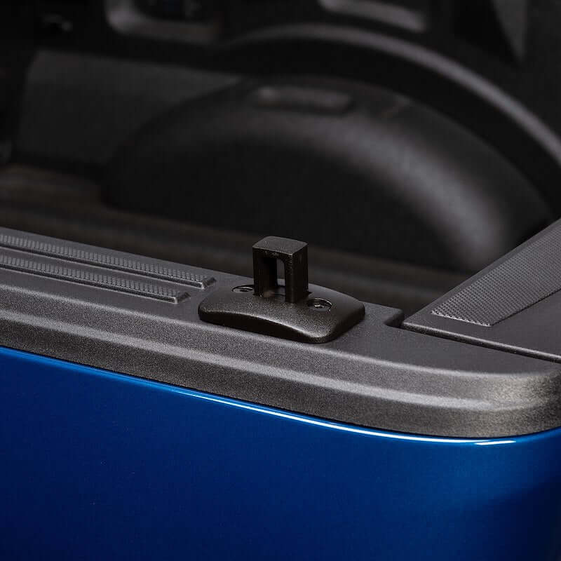 Close-up of Putco Black Stake Pocket Tie-Down Anchor for pickup trucks, mounted in truck bed.