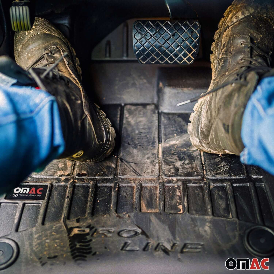 Muddy work boots resting on a black all-weather floor liner in a pickup truck footwell